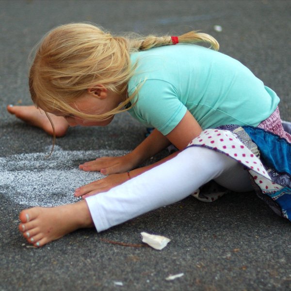Kids are natural Yogis - Little girl doing Upavishta Konasana while playing on the street